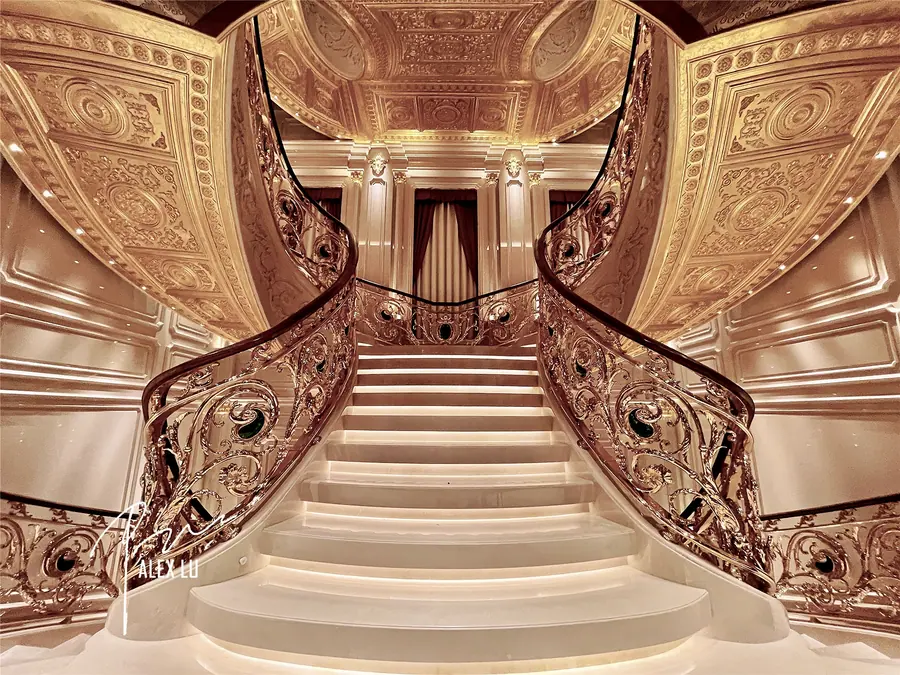 Classical stair hall with ornate railing and stone stairs